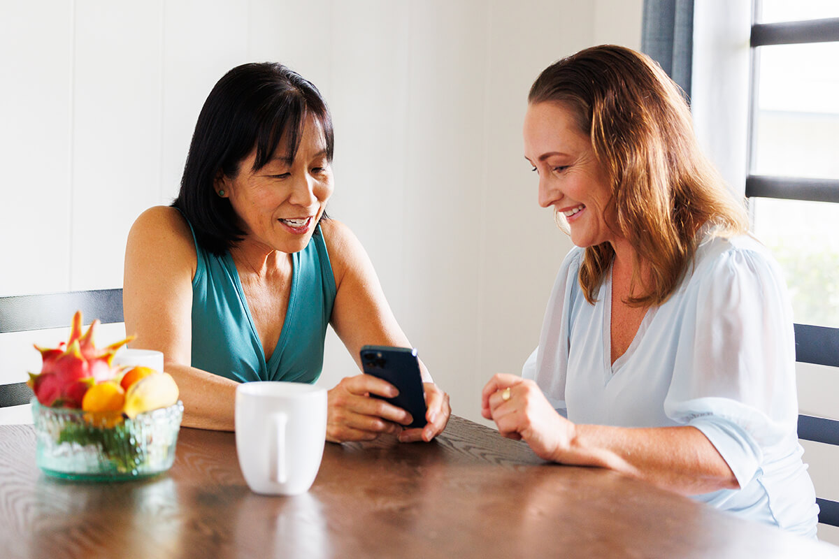 Two Women Looking At Phone